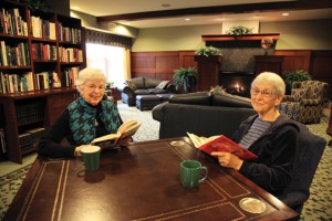 Two women at table in handsome library