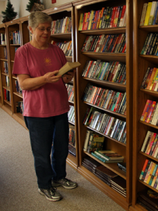 Woman standing at library shelves